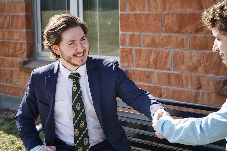 Two men shaking hands while smiling